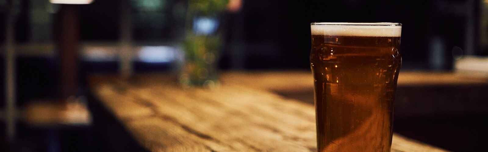 a pint of beer on a bar counter