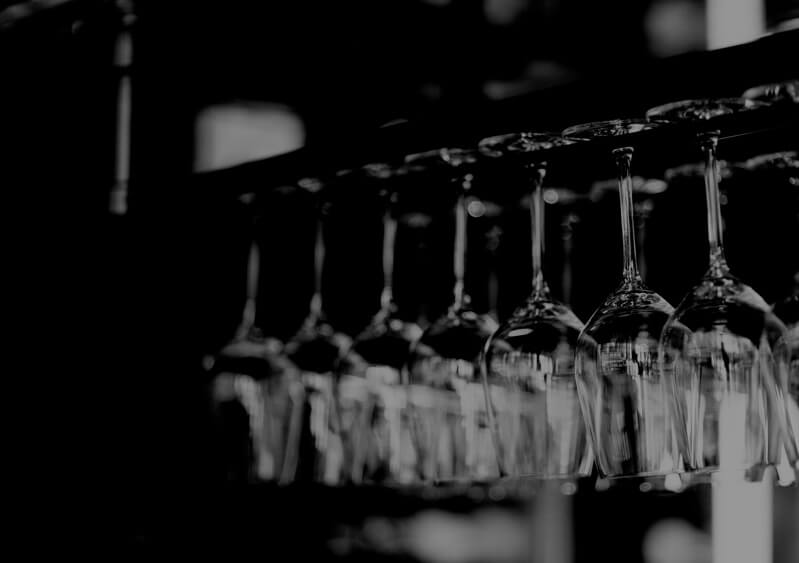 black and white photo of wine glasses hanging